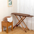 Cette table de repassage dispose de des elements en bois et d'un format compact